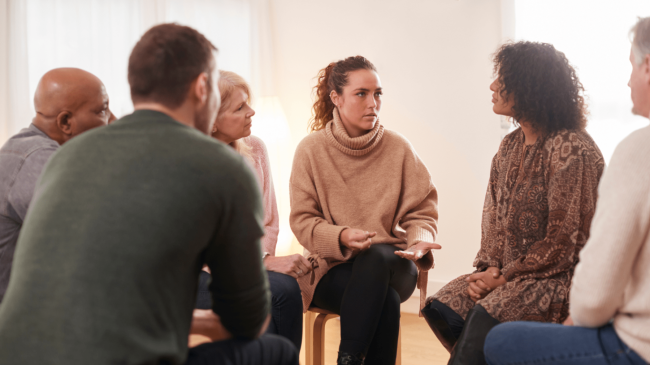 Image of people seated in a circle, talking