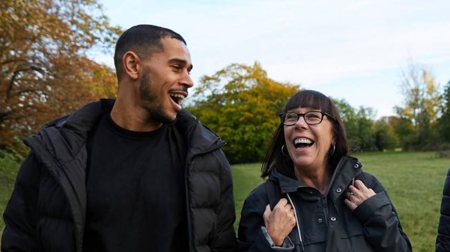 Two people walking and laughing in a park